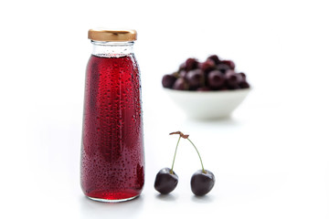 one bottle of cherry juice and fresh cherry on white background