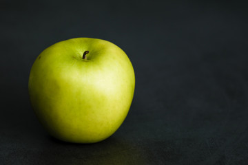 manzana verde en fondo negro