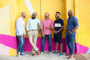 Five men standing together and laughing