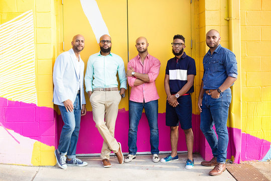 Five young men pose in casual clothes