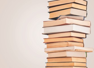 Collection of old books vertical stack on beige background