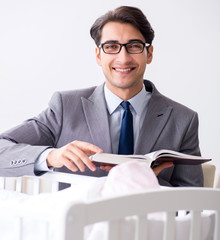 Young businessman trying to work from home caring after newborn