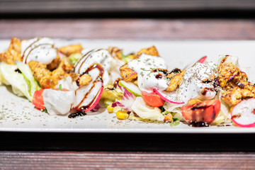 Chicken salad with tomatoes, sweet corn, cucumber, cream and lettuce. Home made food. Concept for a tasty and healthy meal.