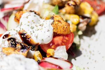 Close up of chicken salad with tomatoes, sweet corn, cucumber, cream and lettuce. Home made food. Concept for a tasty and healthy meal.