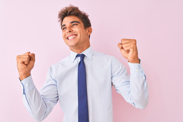 Young handsome businessman wearing shirt and tie standing over isolated pink background celebrating surprised and amazed for success with arms raised and eyes closed. Winner concept.