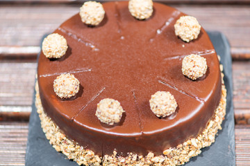 Chocolate cake on a wooden table with nuts