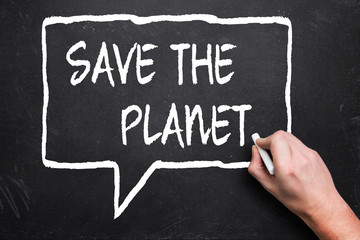 hand writes "save the planet" on a blackboard