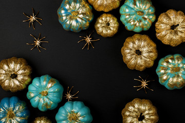 Shiny gold and blue Pumpkins with spiders. Halloween decorations. Trendy holiday concept.