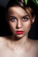 Beauty model girl with perfect make-up and red lips on black background