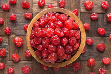 candied fruit, dried cherry with sugar in wooden bowl, top view.