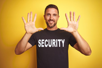Young safeguard man wearing security uniform over yellow isolated background showing and pointing...