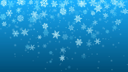 Christmas background of complex blurred and clear falling snowflakes in light blue colors with bokeh effect