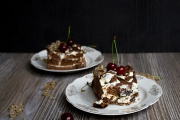 Chocolate cake with cherries on wooden background