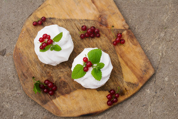 Homemade pink marshmallow and pavlova cake with strawberry, blackberry, currant, cherry and mint leaf. top view.