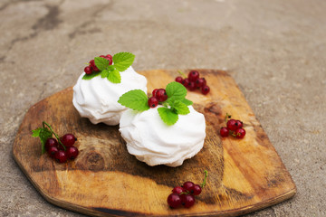 Homemade pink marshmallow and pavlova cake with strawberry, blackberry, currant, cherry and mint leaf.