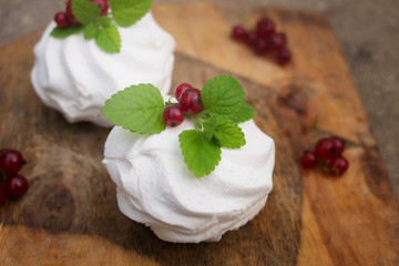 Homemade pink marshmallow and pavlova cake with strawberry, blackberry, currant, cherry and mint leaf.