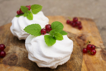 Homemade pink marshmallow and pavlova cake with strawberry, blackberry, currant, cherry and mint leaf.