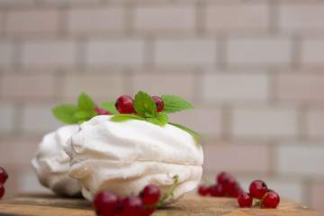 Homemade pink marshmallow and pavlova cake with strawberry, blackberry, currant, cherry and mint leaf.