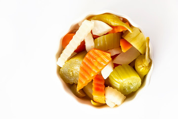 Assorted pickles vegetables carrot, chili, radish in white ceramic bowl. Top view. Isolated. Copy space. Top view.