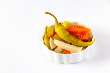 Assorted pickles vegetables carrot, chili, radish in white ceramic bowl. Top view. Isolated. Copy space.