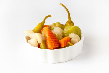 Assorted pickles vegetables carrot, chili, radish in white ceramic bowl. Top view. Isolated. Copy...