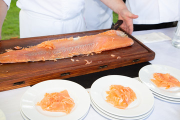 Man cook chef with fresh salmon fillet in party event