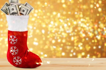 Lot of dollars in a Christmas sock on background