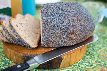 Fresh homemade bread on cutting board with knife on colorful breakfast table