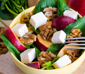 Spinach salad with nuts and apples served on table