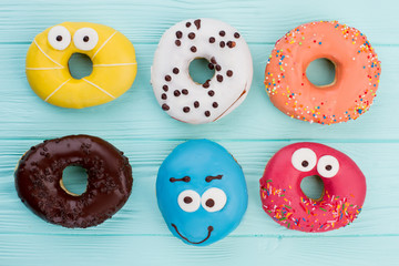 Naklejki  Group of different donuts on color background. Donuts decorated with frosting. Delicious pastry for kids holiday.
