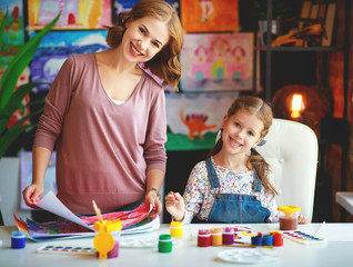 mother and child daughter painting draws in creativity in kindergarten.