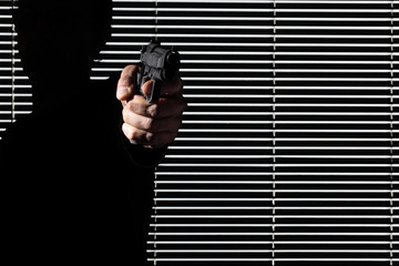 man hand aim a gun isolated on black window,  personal defense or theft and robbery concept
