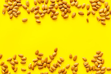Healthy snack with almonds on yellow background top view mock up