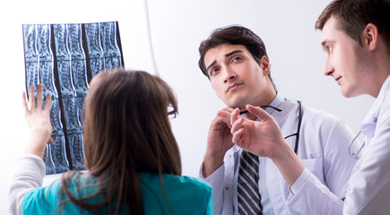 Three doctors discussing scan results of x-ray image