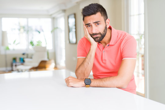 Handsome hispanic man wearing casual t-shirt at home thinking looking tired and bored with depression problems with crossed arms.