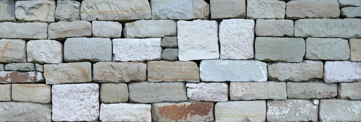 Alte Steinmauer aus unterschiedlichen, viereckig gehauenen Natursteinen ohne Mörtel