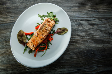 top view of tasty salmon fillet with green salad and arugula