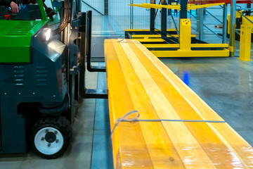 Forklift loads boards. Lumber warehouse. Forklift in warehouse construction company. Storage of building materials. Industrial wood for construction. Boards on the forklift .