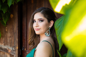 Fototapeta na wymiar Girl in glamorous green dress and with beautiful silver earring