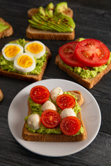 Tomato and Mozzarella Avocado Toast on a Wooden Table