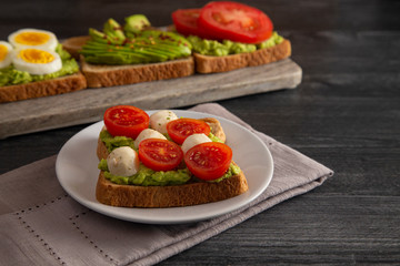 Tomato and Mozzarella Avocado Toast on a Wooden Table