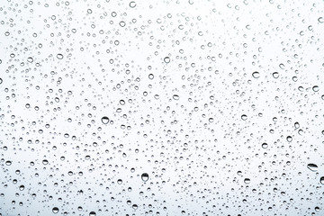 of rain standing on a glass. water droplets on glass with white background
