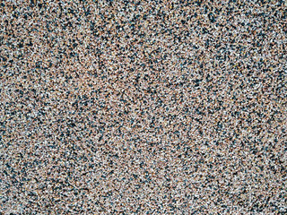 Close up of decorative quartz sand epoxy coated floor or wall coating with grey, black and white...