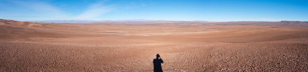 Fototapeta na wymiar The vast extensions of Atacama Desert, walking below the sun inside the loneliness of this arid landscape is an amazing experience in the search of meteorites coming from the outer space