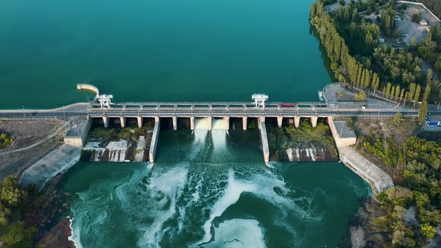 Aerial panoramic view of concrete Dam at reservoir with flowing water, hydroelectricity power station