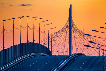 Empty highway leads into the sunset. Modern road at sunset. Expressway. Road architecture....