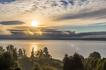 Fototapeta na wymiar A dramatical sky view in between the clouds over Rupanco Lake, one of the Great lakes in Southern Chile during sunrise an amazing volcanic landscape with the lake and the forests, Chile 