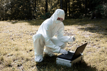 Ecological problem. Pollution. Examine oxygen. Scientist in protective mask and suit taking water samples from river. Chemist makes an analysis of the environment for radiation. Saving planet earth.