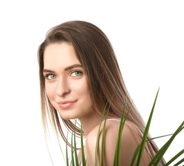 Beautiful young woman with tropical leaf on white background