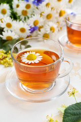 Cup of tasty chamomile tea on light table